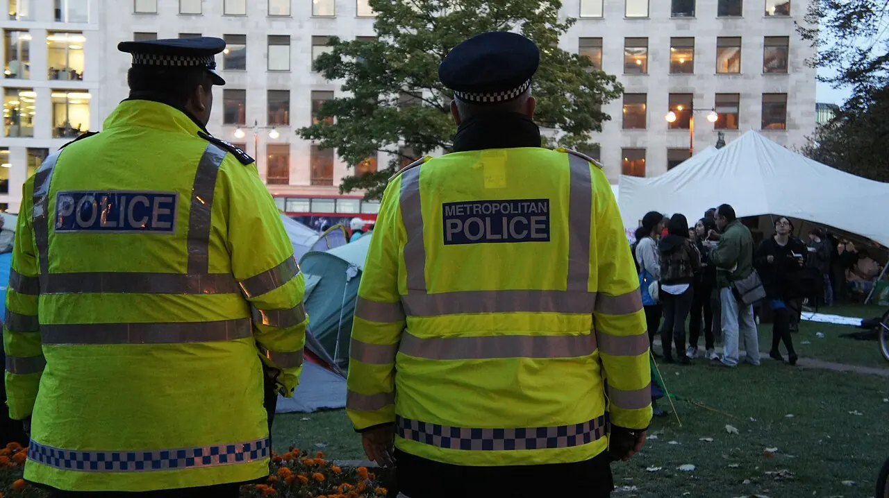 Dos agentes de la Metropolitan Police de Londres observan una acampada de protesta